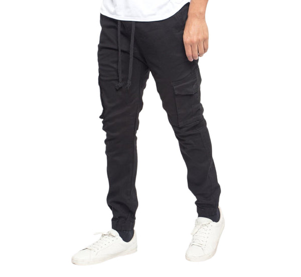 Person wearing black cargo pants and white sneakers on a white background