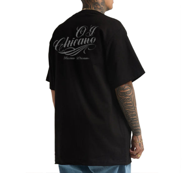 Person wearing a black t-shirt with 'OJ Chicano' text on the back, standing against a white background.