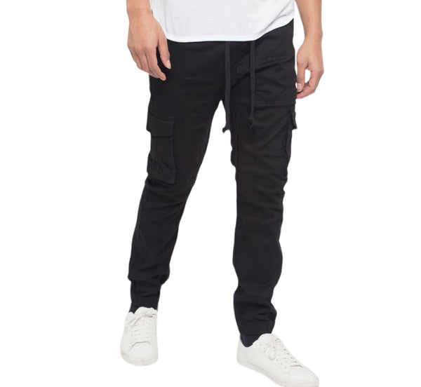 Person wearing black cargo jogger pants and white sneakers on a white background
