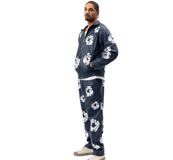 Man wearing a navy blue tracksuit with white floral patterns on a white background