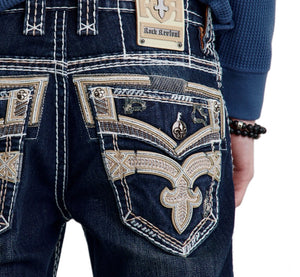 Close-up of dark blue jeans with intricate white stitching and a brand label on a white background.