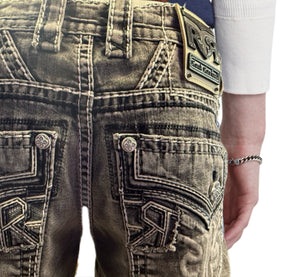 Close-up of a person wearing distressed jeans with Rock Revival logos.