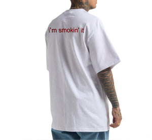 Person wearing a white t-shirt with 'i'm smokin' it' text on the back, standing against a white background.