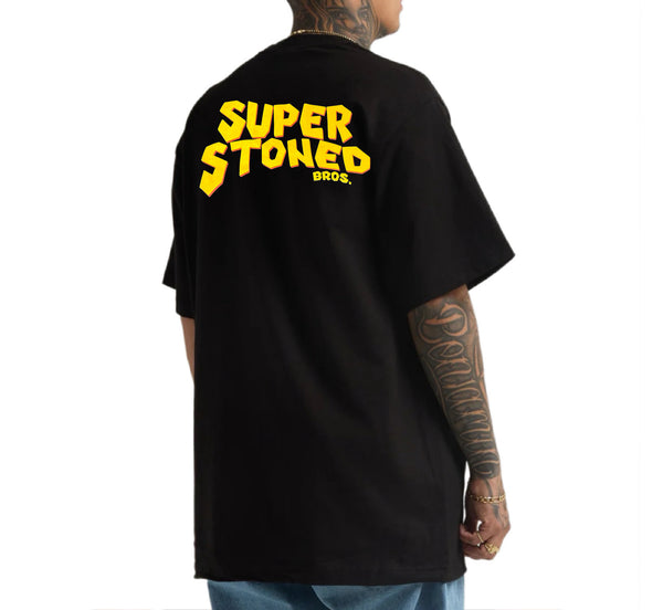 Black t-shirt with yellow text 'SUPER STONED BROS.' on the back, worn by a person.