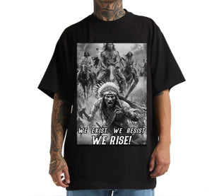 Black t-shirt with a graphic design and text 'WE EXIST. WE RESIST. WE RISE!' worn by a person.