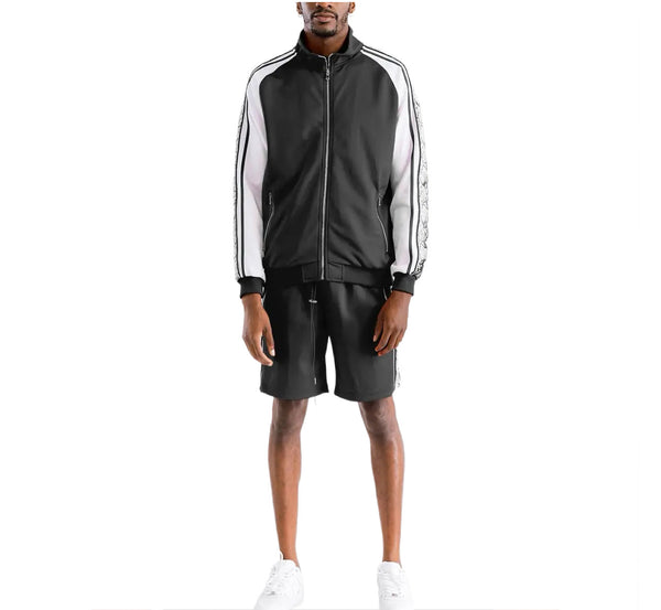 Person wearing a black and white tracksuit with Adidas logo on a white background